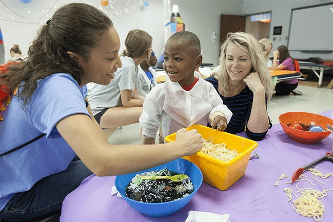Young child being helped with therapy by occupational therapists