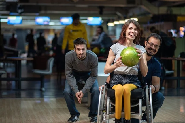 Woman in wheelchair enjoying bowling